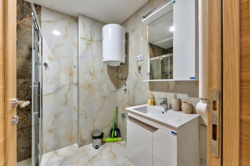 a white bathroom with a sink and a shower at Vip Bogic 79 in Zlatibor