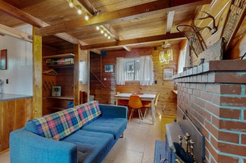 a living room with a blue couch and a table at Cozy Cabin in Government Camp in Government Camp