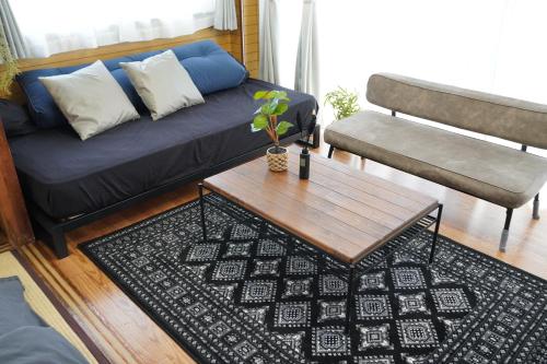 a living room with a blue couch and a coffee table at 駅徒歩4分 都心の広々空間 各階貸切 銀座 お台場 豊洲すぐ 田町 三田駅も利用可 in Tokyo