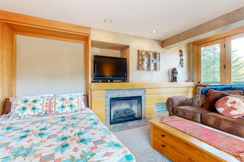 a bedroom with a bed and a tv and a fireplace at Shoshone 1913 in Big Sky
