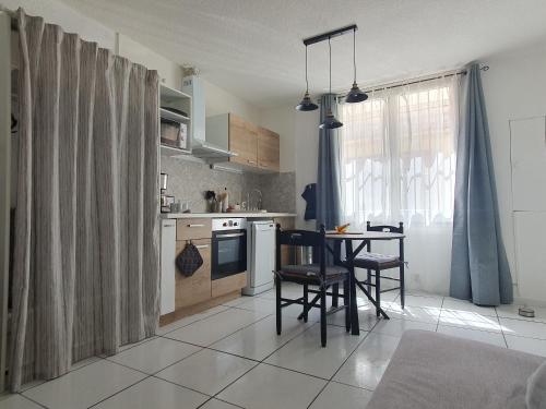 une cuisine avec une table et des chaises dans une pièce dans l'établissement Beau studio rénové en centre-ville de Sète, à Sète