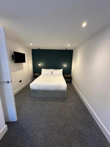 a bedroom with a white bed and a green wall at St Malcolms Wynd in Angus