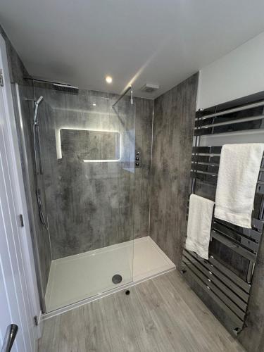 a shower with a glass door in a bathroom at St Malcolms Wynd in Angus