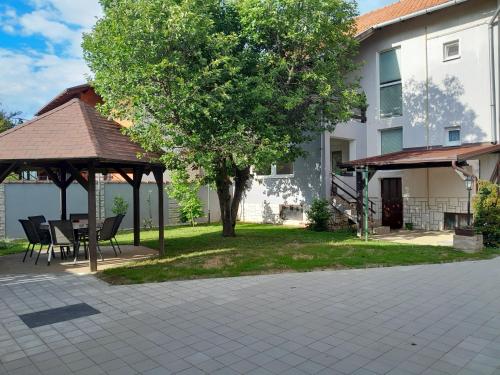 a patio with a table and a gazebo next to a house at Apartman kod dide i bake in Vukovar