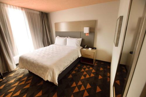 a hotel room with a bed and a window at Wyndham Houston Hobby Airport in Houston