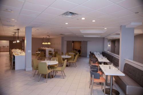 a dining room with tables and chairs in a restaurant at Wyndham Houston Hobby Airport in Houston