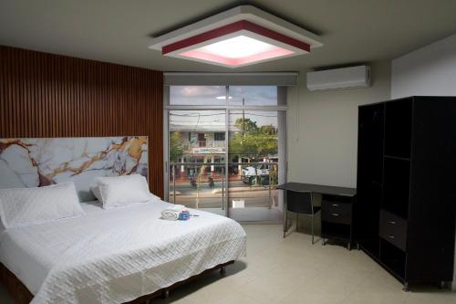 a bedroom with a bed and a large window at Hotel y Restaurante BCB La Jagua in La Jagua de Ibirico