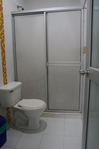 a bathroom with a toilet and a glass shower at Hotel y Restaurante BCB La Jagua in La Jagua de Ibirico