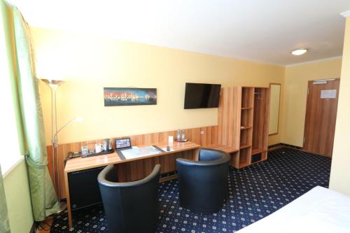 a hotel room with a desk and two chairs at Hotel Deutscher Hof in Babenhausen