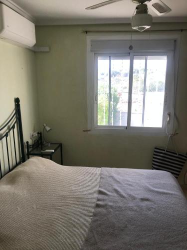 a bedroom with a bed and a window at house with flowers in Gran Alacant