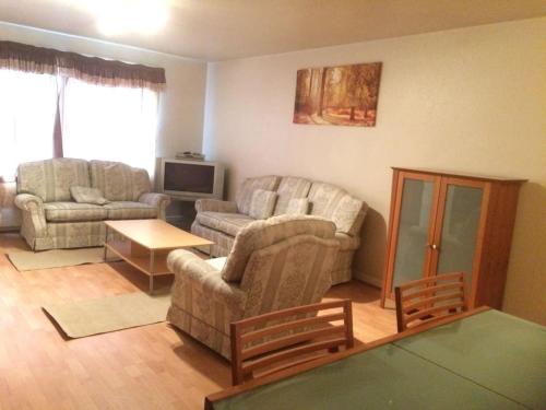 a living room with two couches and a tv at 1 bedroom spacious flat in Dewsbury