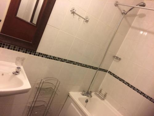 a bathroom with a shower and a tub and a sink at 1 bedroom spacious flat in Dewsbury