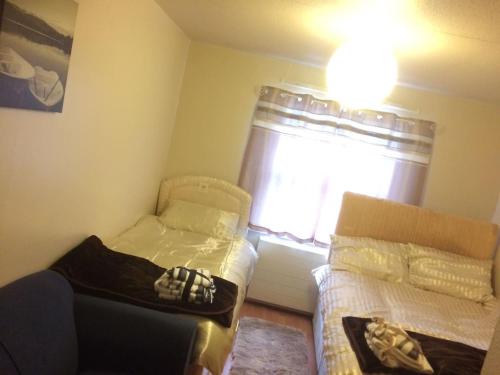 a small bedroom with two beds and a window at 1 bedroom spacious flat in Dewsbury