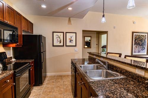 a kitchen with a sink and a black refrigerator at 1 BR Top Floor - private balcony & views 5304 in Saint Augustine