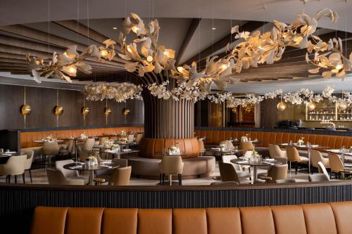 a restaurant with tables and chairs and a large chandelier at InterContinental Athenee Palace Bucharest by IHG in Bucharest