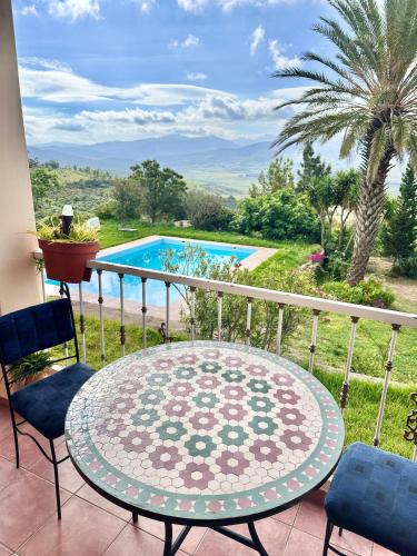 a balcony with a table and chairs and a pool at Dar Bakkali Nadi in Tangier