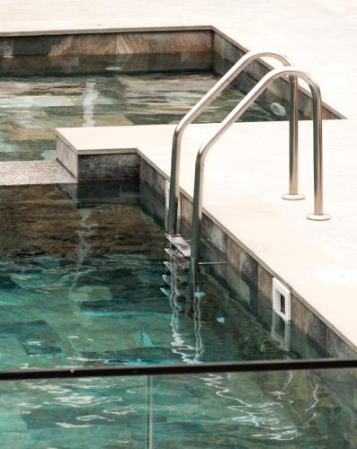 a swimming pool with a water fountain at Bianca Hotel & Villa in Tirana