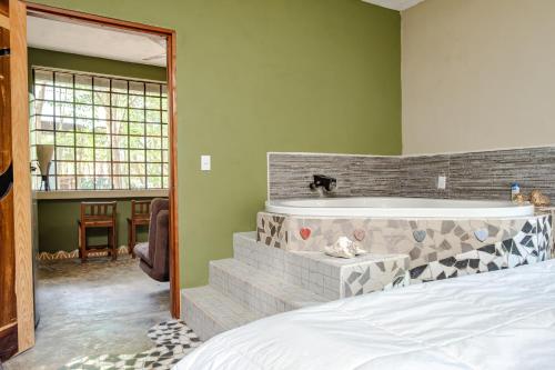 a bedroom with a bed and a bath tub at Hokhmah Heart Hotel in Puerto Morelos
