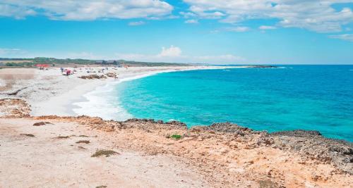 - une plage avec des personnes se promenant sur le sable et l'océan dans l'établissement La Casetta di Lally, à Cabras