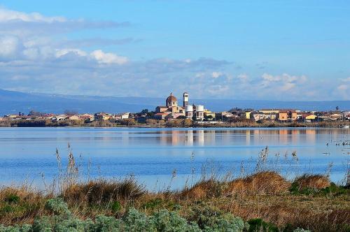 Une grande masse d'eau avec une ville en arrière-plan dans l'établissement La Casetta di Lally, à Cabras