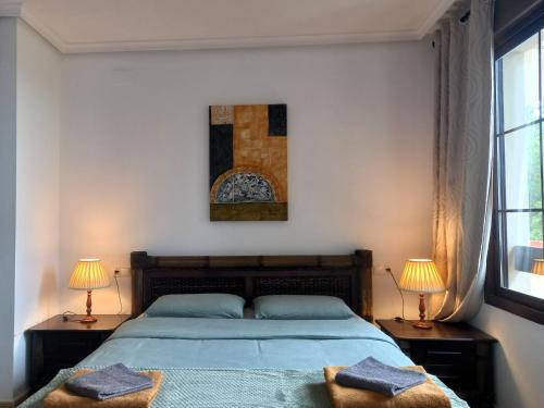 a bedroom with a large bed with two lamps at Townhouse Altea Hills in Altea