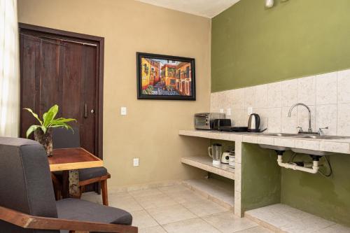 a kitchen with a sink and a counter with a table at Hokhmah Heart Hotel in Puerto Morelos