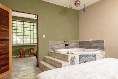 a bedroom with a bath tub and a bed at Hokhmah Heart Hotel in Puerto Morelos