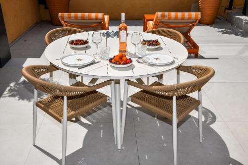 - une table blanche avec des chaises et de la nourriture dans l'établissement A 5 min à pied de la plage et 10 min du port, T2 vue mer avec vaste terrasse et parking privé - prestations haut de gamme, à Sanary-sur-Mer