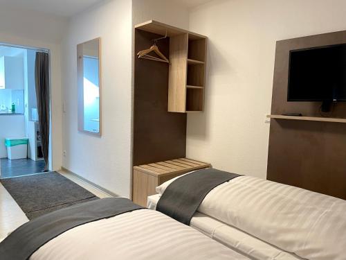 a bedroom with two beds and a flat screen tv at Hana Aparthotel in Hamburg