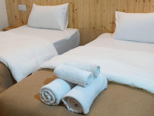 two beds with towels sitting on a table at Bhimtal Birding Lodge in Bhowāli