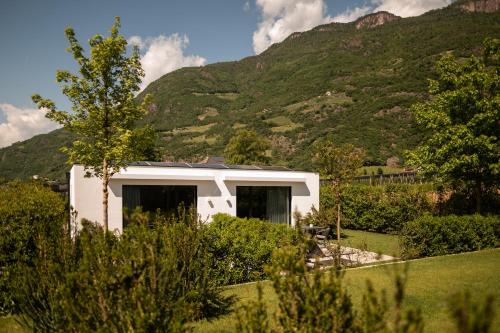 a white house in front of a mountain at Agriturismo Insolito in Terlano