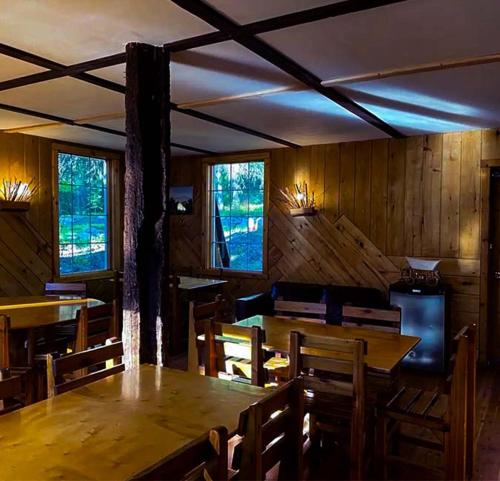 a dining room with a table and chairs and windows at Rustic Beaverfoot Lodge Room N3 in Parson