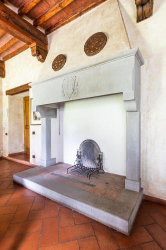 a fireplace in a room with a brick floor at Agriturismo Borgo dei Ricci in Impruneta
