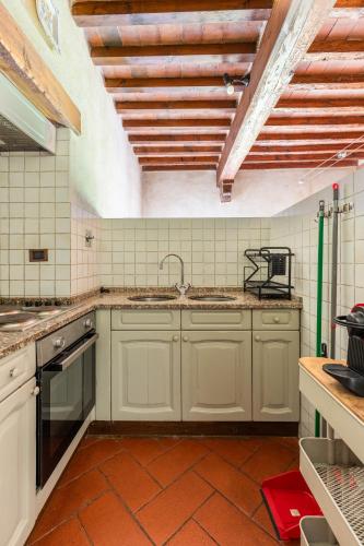 a kitchen with white cabinets and a sink at Agriturismo Borgo dei Ricci in Impruneta