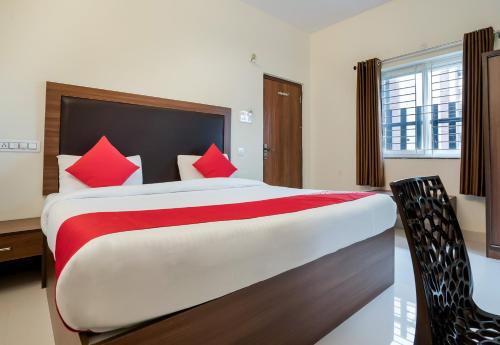 a bedroom with a large bed with red pillows at Super Hotel O Gokul Grand Near SR Nagar Police Station in Hyderabad
