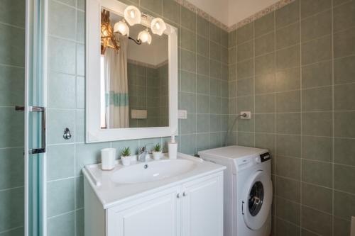 a bathroom with a sink and a washing machine at Mare e Centro 5 min auto - con Wi-fi, Netflix e A-C in Pula
