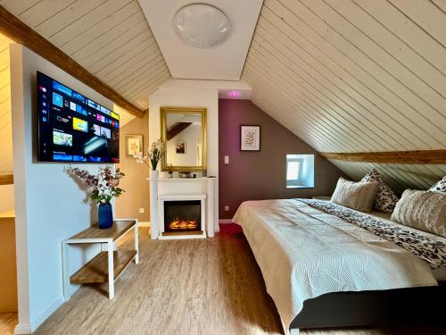 a bedroom with a bed with a fireplace and a tv at Lot54 Holiday Homes in Feuerscheid