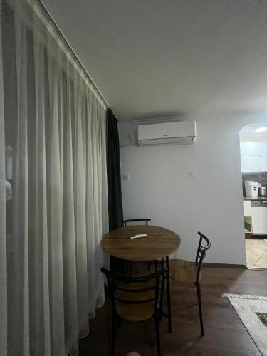 a table and chairs in a room with a curtain at Bazaar Luxury Apartment in Skopje in Skopje
