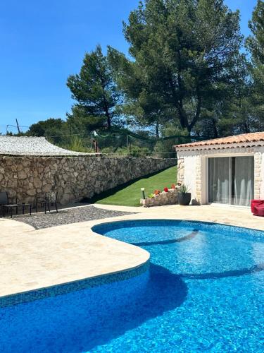 - une piscine dans une cour dotée d'un mur en pierre dans l'établissement Jolie maison avec vue sur piscine, à Bouc-Bel-Air