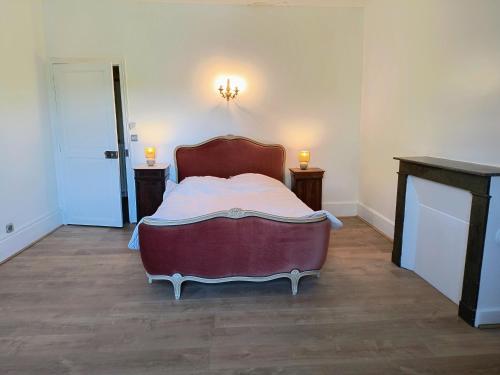 a bedroom with a bed with two candles on two tables at Village Collection Le Vauvert in Ormoy-la-Rivière
