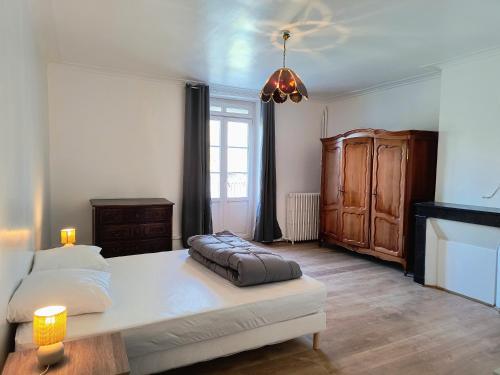 a bedroom with a large bed with two candles on it at Village Collection Le Vauvert in Ormoy-la-Rivière