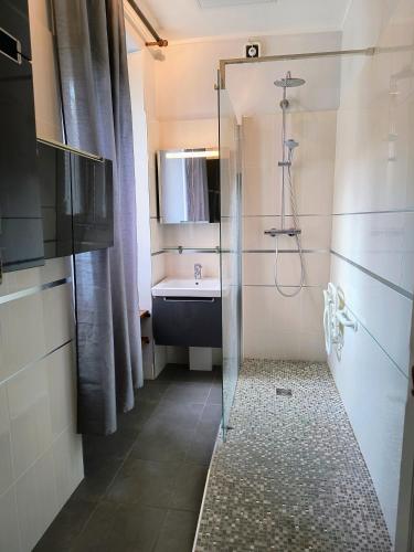 a bathroom with a shower and a sink at Village Collection Le Vauvert in Ormoy-la-Rivière