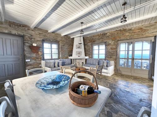 a living room with a table and a stone wall at The Traditional Stone Villa in Koundouros