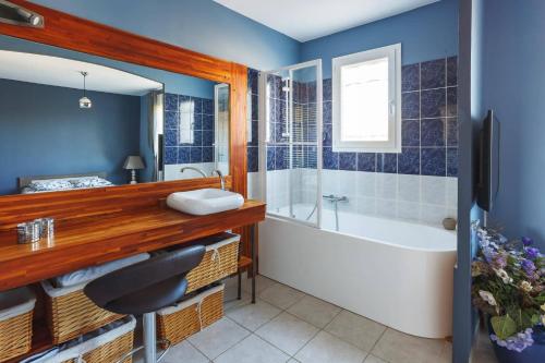 une salle de bain avec une baignoire et un lavabo dans l'établissement Villa Carcassonne by Villa Plus, à Montirat