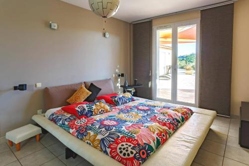 - un lit avec une couverture colorée dans une chambre dans l'établissement Villa Carcassonne by Villa Plus, à Montirat