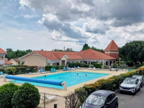 dos coches estacionados frente a una piscina en Appt T4 Résidence Le Cordouan 3 étoiles côté Piscine, en Soulac-sur-Mer