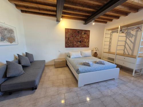 a living room with a bed and a couch at Appartamento Roma in Gaggiano