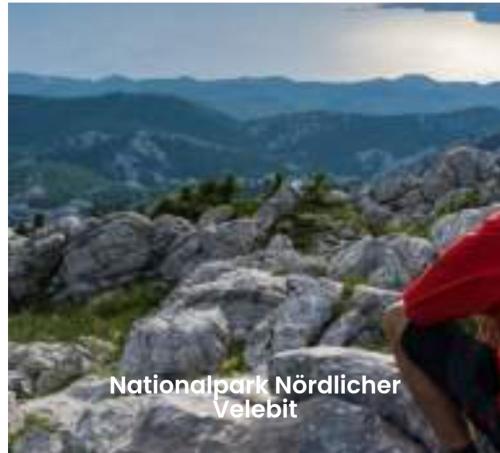 a person sitting on top of a rocky mountain at Vila Natasa Apartment 5 near Plitvice in Vrhovine
