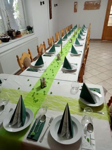 a long table with green napkins and plates on it at Penzion JAS in Zuberec