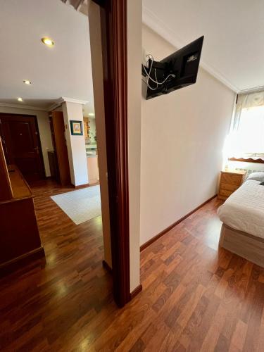 ヌエバ・デ・リャネスにあるGestiona2R - Apartamento para dos céntrico en Nueva de Llanesの壁にテレビが備わる客室です。